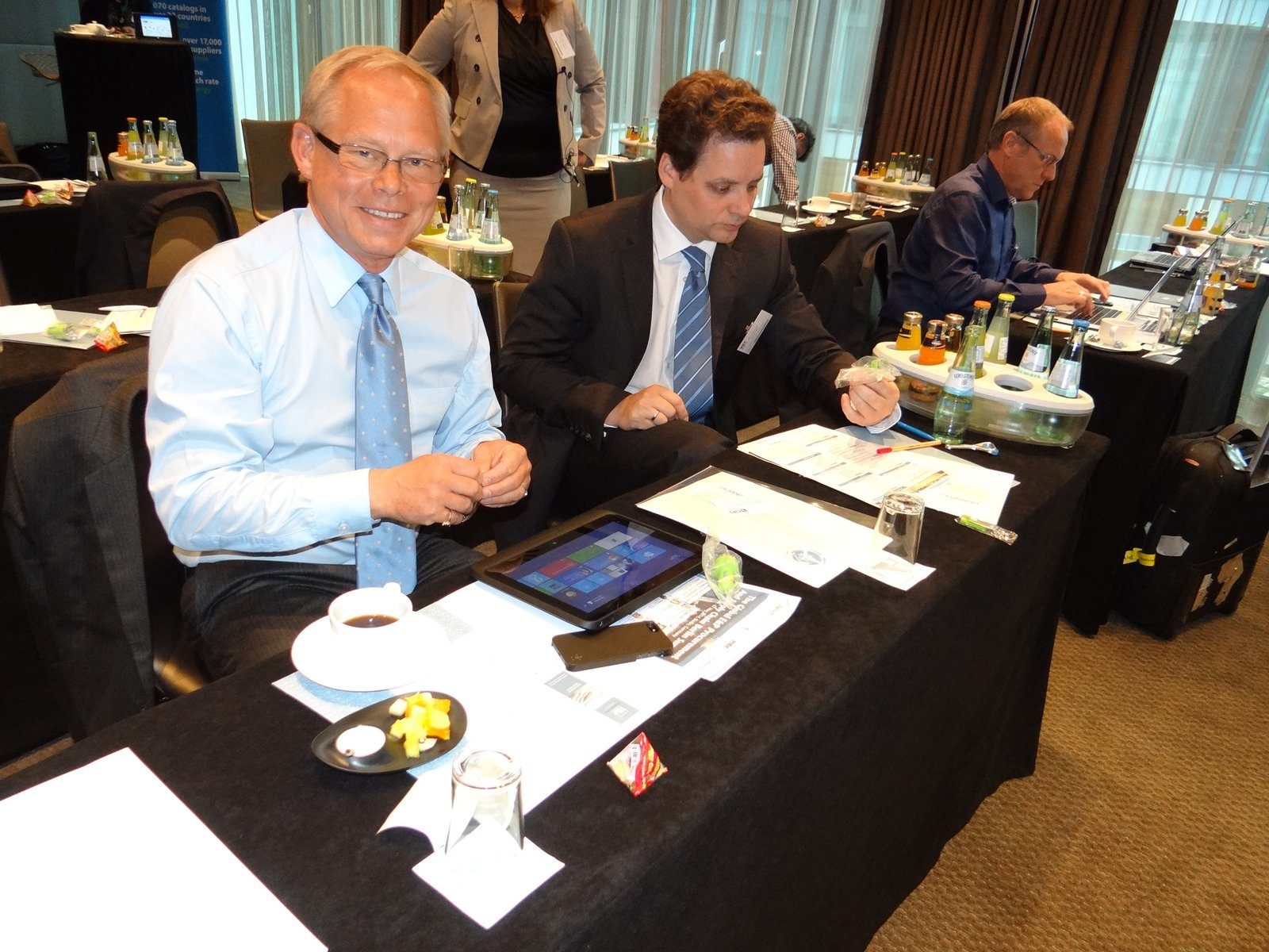 Delegates working at tables with laptops and documents at a previous Zenith Group event